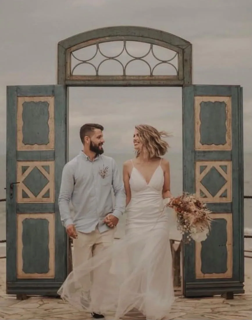 Casal de noivos em frente a portal antigo azul