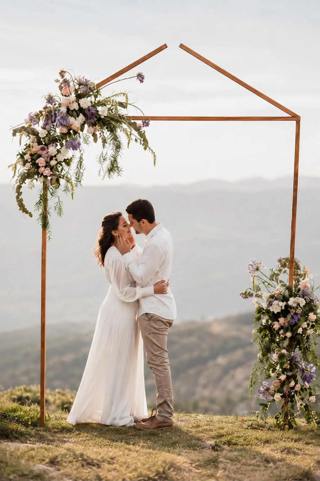 Casal abraçado sob arco de flores no alto do morro