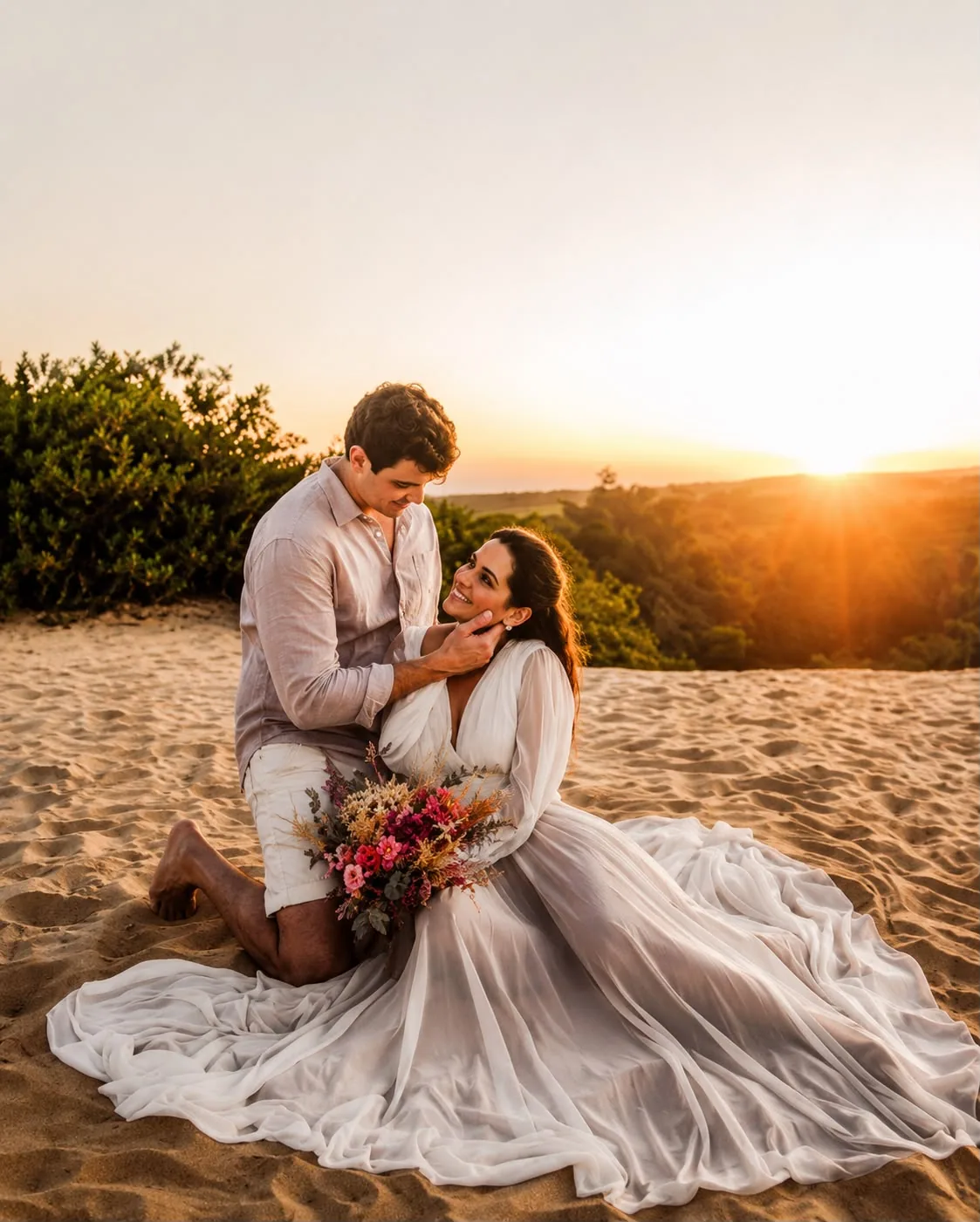 Casal sentado na areia ao pôr do sol com vestido de cauda