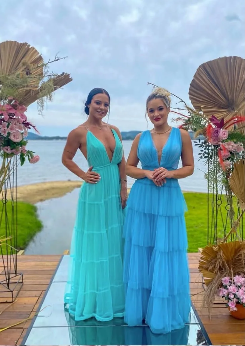 Duas madrinhas em vestidos verde água à beira da lagoa